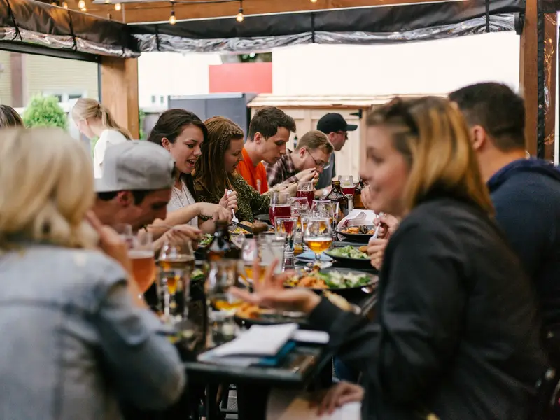 Guests at a community dinner talking along a long laid table