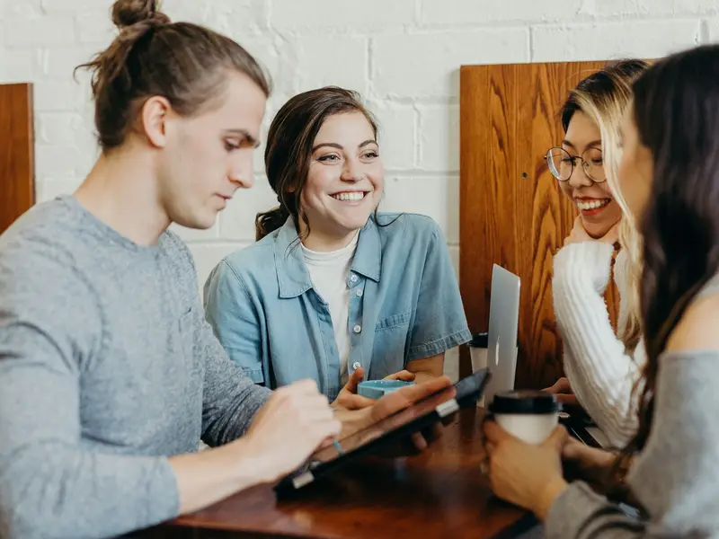 A small group at a meetup discussing a project over laptops